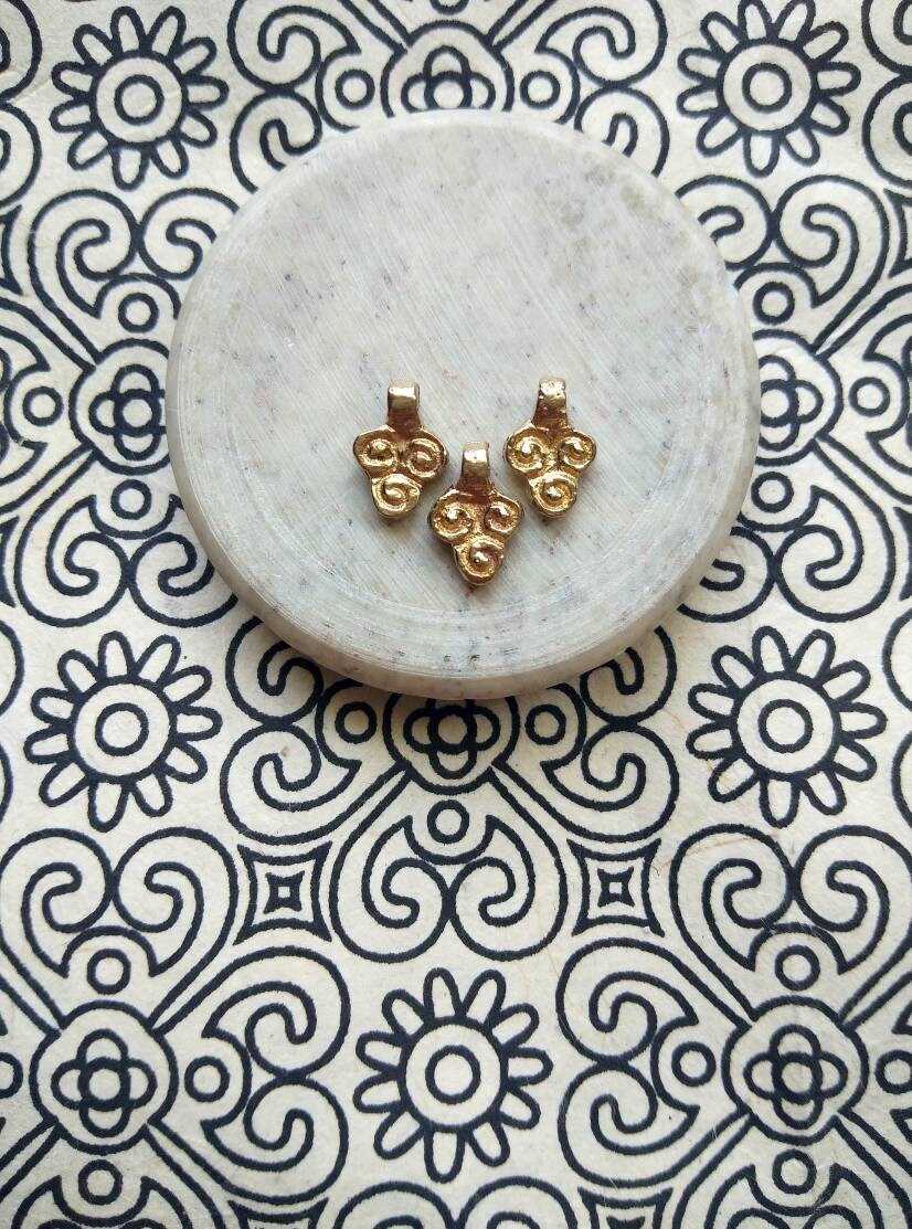 Small brass charms crafted for jewelry making